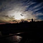 A photograph of a city skyline silhouetted at sunset.