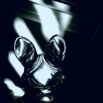 A photograph of a glass bunny figurine casting strange light on a wall.