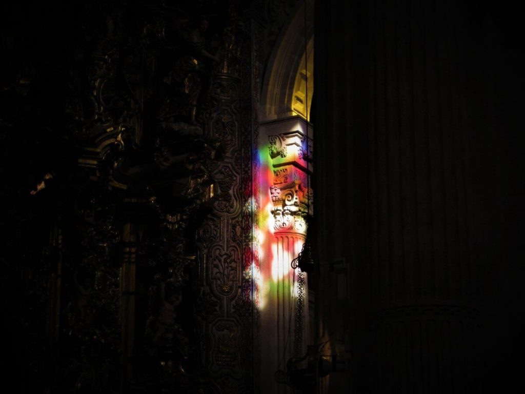 A photograph of a carved column lit up at night.