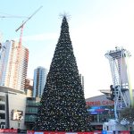 A photograph of a Christmas tree in the middle of a city.