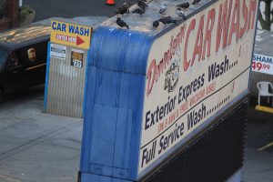 A photograph of a dingy car wash sign.