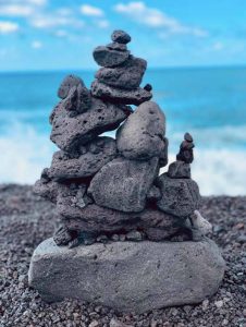 A photograph of an inuksuk at a beach.