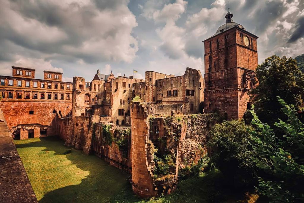 A photograph of the ruins of a majestic castle under a cloudy sky.