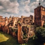 A photograph of the ruins of a majestic castle under a cloudy sky.