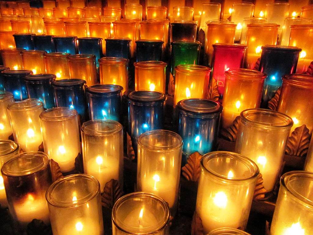 A photograph of dozens of lit candles.